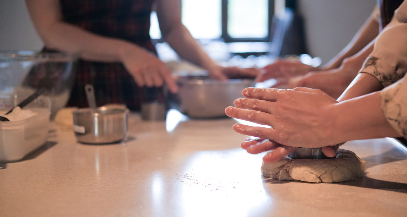 A young person learning kitchen skills in a hands-on cooking session