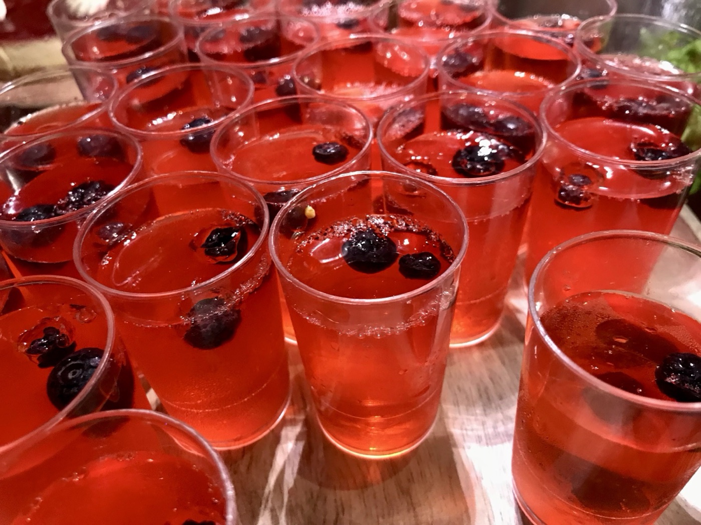 Berry jelly cups lined up on a wooden board