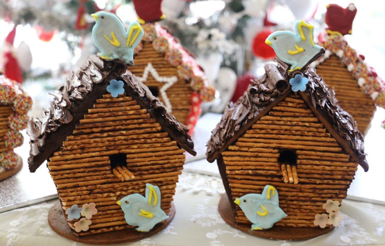 Close-up of a gingerbread birdhouse with pretzel-stick walls