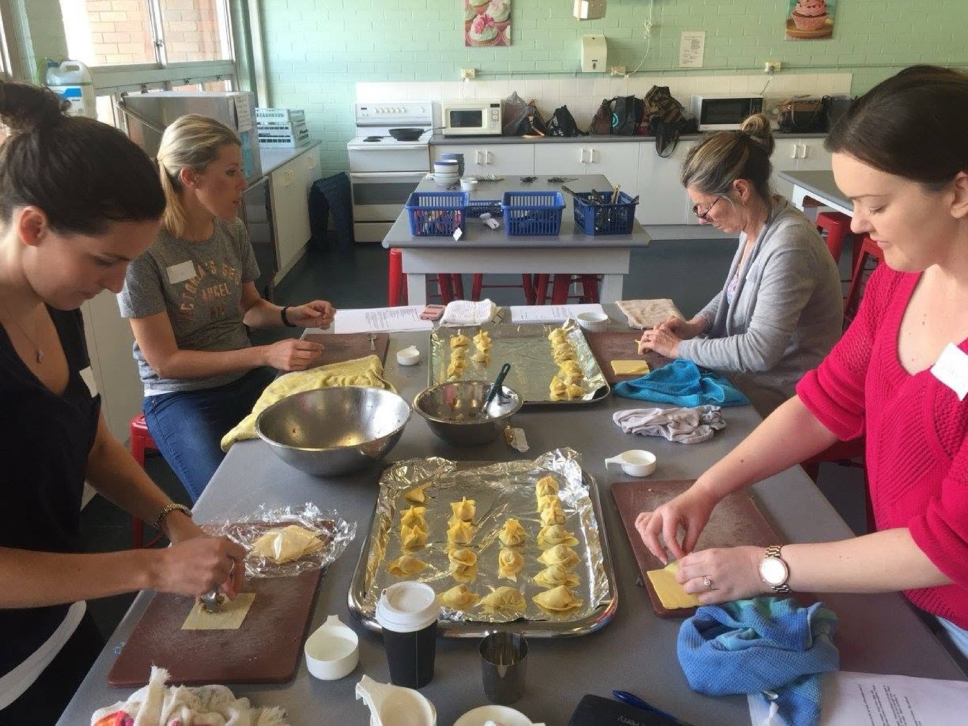 Folding dumplings together at a shared bench
