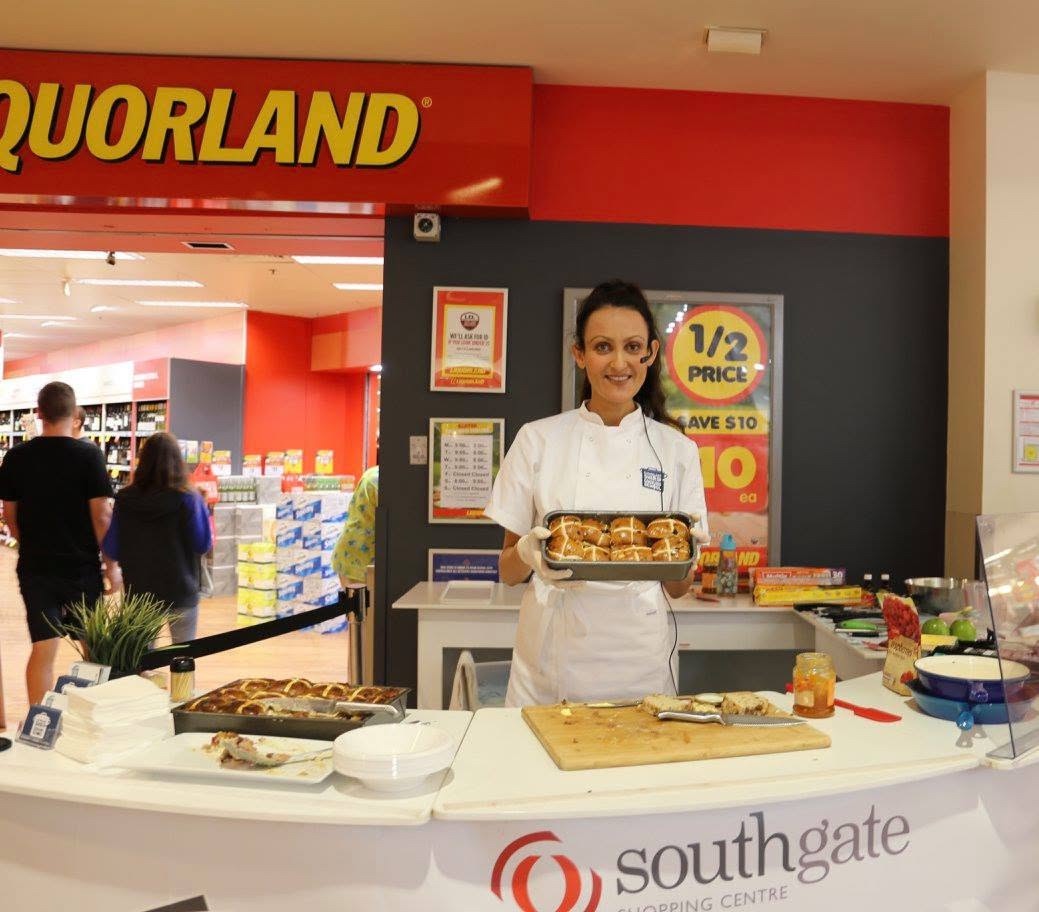 Yvonne with a tray of hot cross buns at a shopping centre demonstration